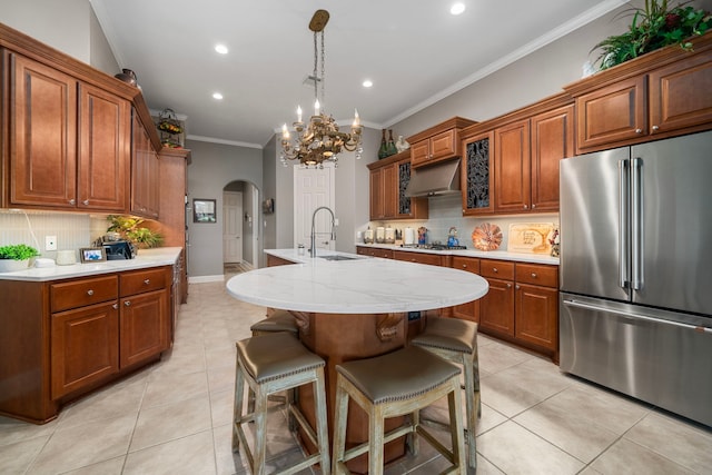 kitchen featuring pendant lighting, sink, tasteful backsplash, a kitchen island with sink, and appliances with stainless steel finishes