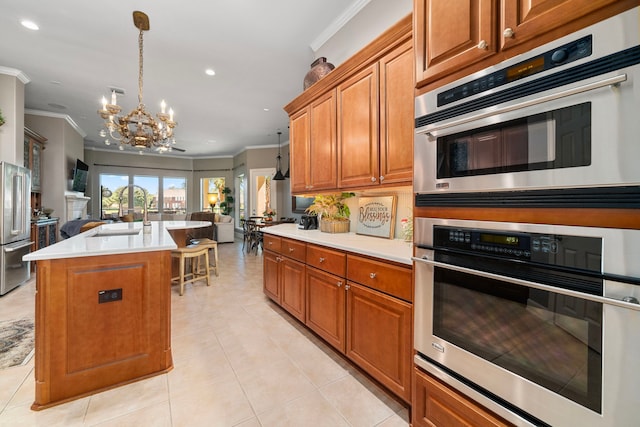 kitchen with sink, a kitchen island with sink, appliances with stainless steel finishes, an inviting chandelier, and crown molding