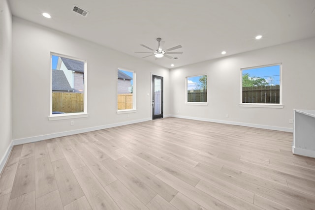 spare room with light hardwood / wood-style flooring, ceiling fan, and plenty of natural light