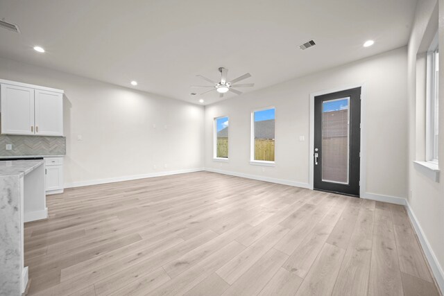 unfurnished living room featuring ceiling fan and light wood-type flooring