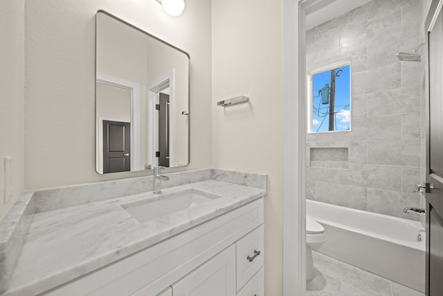 full bathroom with vanity, tiled shower / bath combo, and toilet