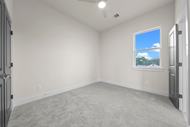 spare room featuring light carpet and ceiling fan