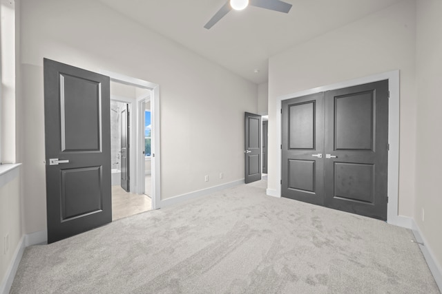 unfurnished bedroom featuring light colored carpet, connected bathroom, and ceiling fan