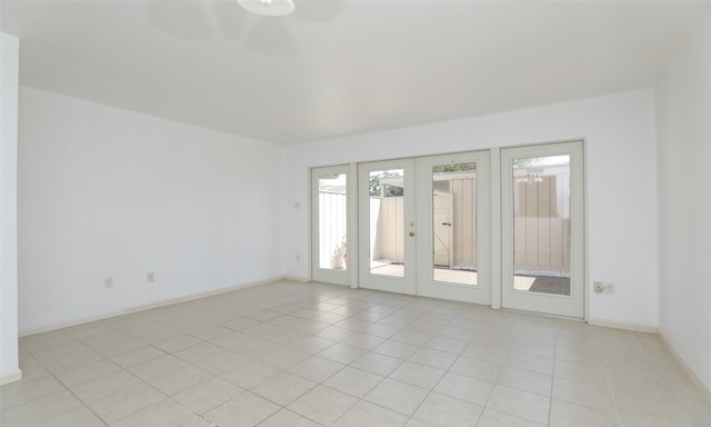 tiled empty room featuring french doors