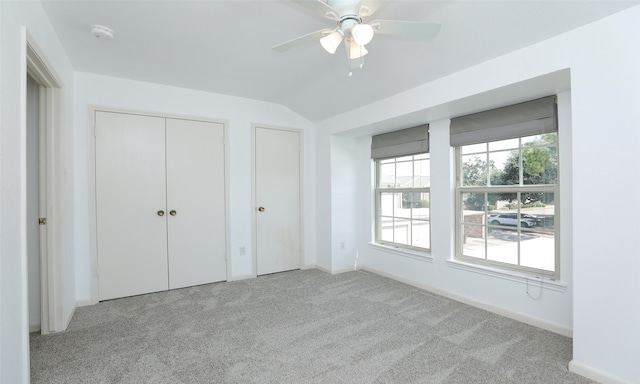 unfurnished bedroom with ceiling fan, vaulted ceiling, and light colored carpet