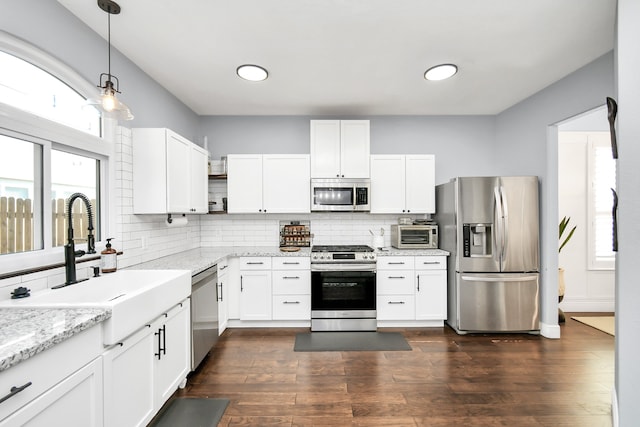 kitchen with dark hardwood / wood-style floors, stainless steel appliances, and white cabinets