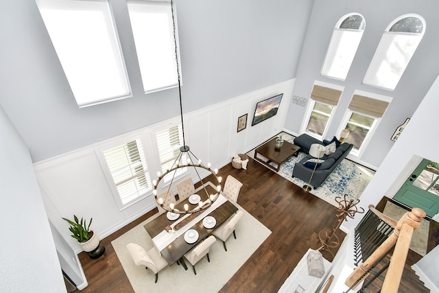 living room with a high ceiling, dark wood-type flooring, and a chandelier