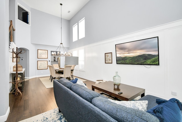 living room with hardwood / wood-style flooring, a notable chandelier, high vaulted ceiling, and a healthy amount of sunlight