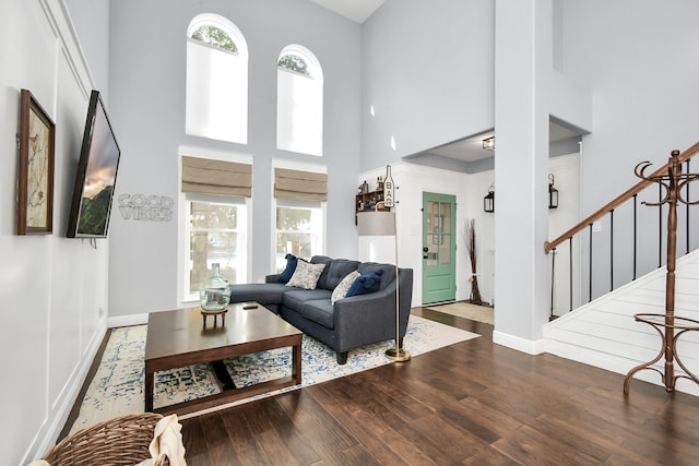 living room with wood-type flooring, a high ceiling, and plenty of natural light