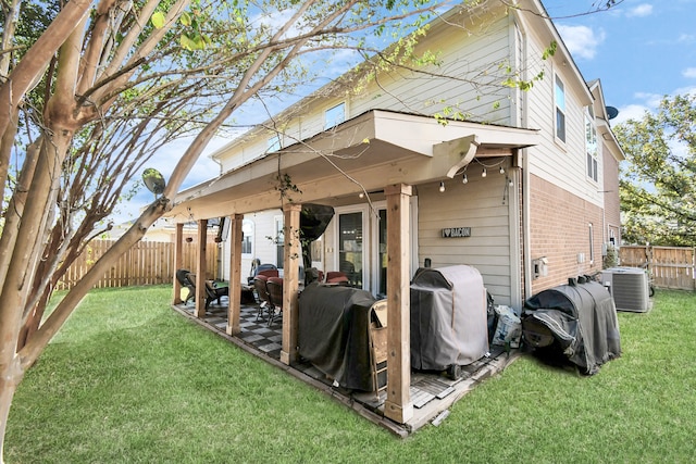 rear view of house featuring a patio, central AC unit, and a yard