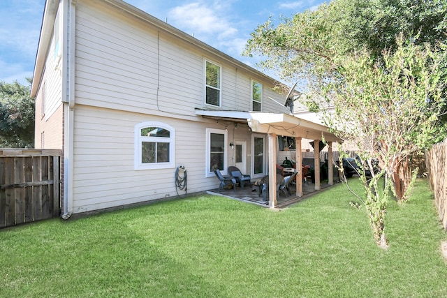 back of property featuring a lawn and a patio