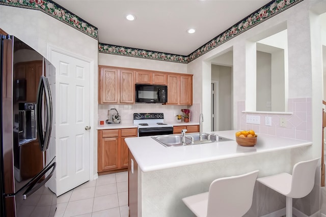 kitchen with white electric stove, sink, kitchen peninsula, and stainless steel refrigerator with ice dispenser