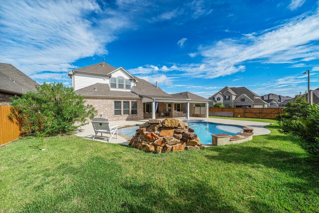 back of house featuring a fenced in pool, a yard, and a patio