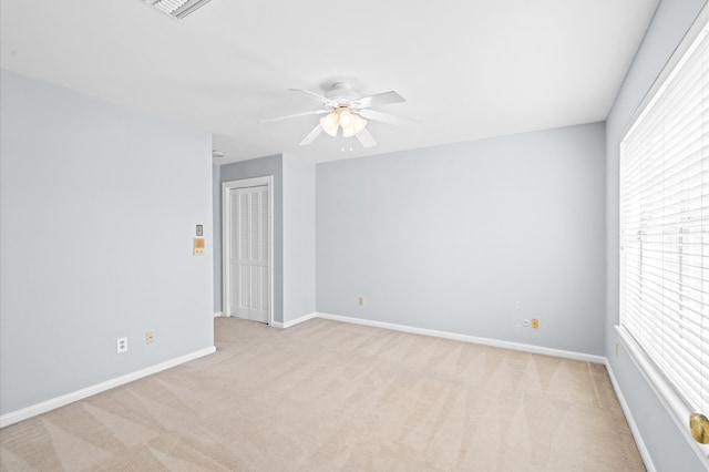 empty room with ceiling fan and light colored carpet