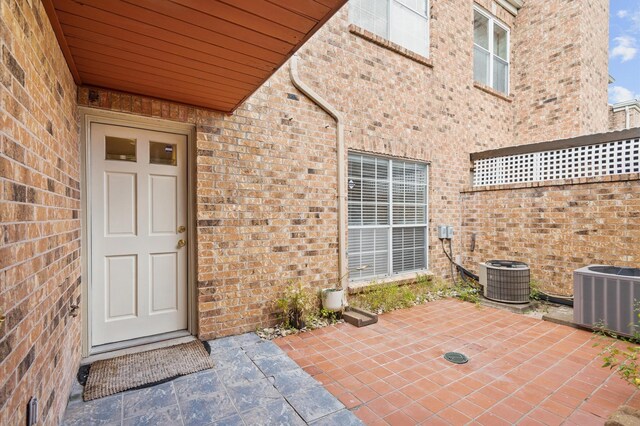 600 Wilcrest Dr Unit 8, Houston, TX 77042 - doorway to property featuring central air condition unit, brick siding, and a patio area