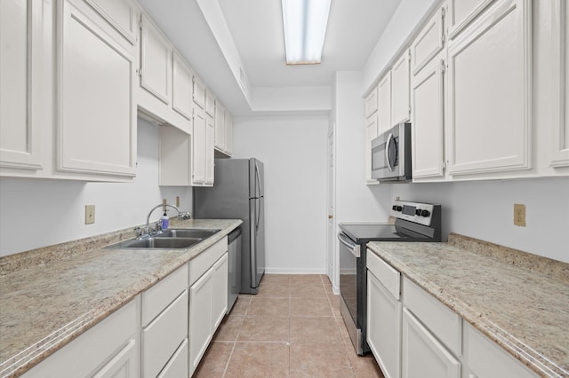 kitchen with light tile patterned floors, white cabinets, stainless steel appliances, and sink