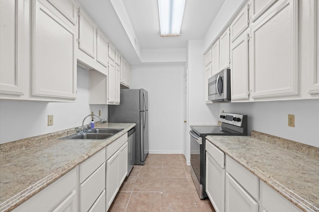 600 Wilcrest Dr Unit 8, Houston, TX 77042 - kitchen featuring appliances with stainless steel finishes, a sink, light tile patterned flooring, white cabinetry, and baseboards
