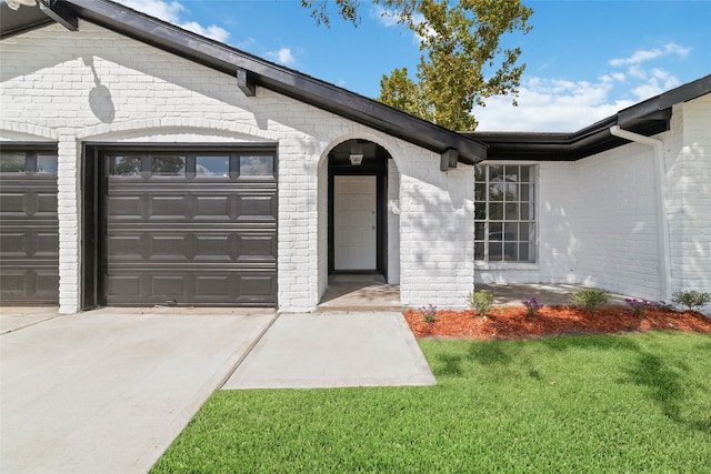 entrance to property featuring a lawn and a garage