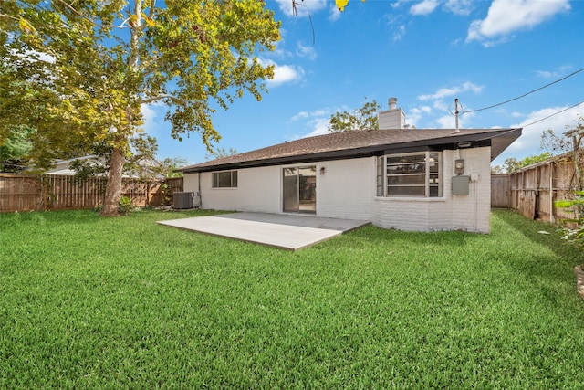 rear view of property with a lawn, a patio, and cooling unit