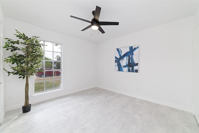 empty room with ceiling fan and a wealth of natural light