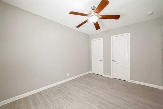 unfurnished bedroom featuring ceiling fan, a textured ceiling, and light hardwood / wood-style floors