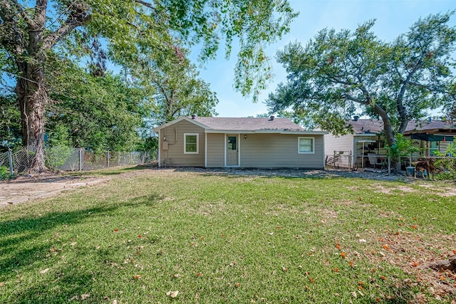 rear view of property featuring a yard