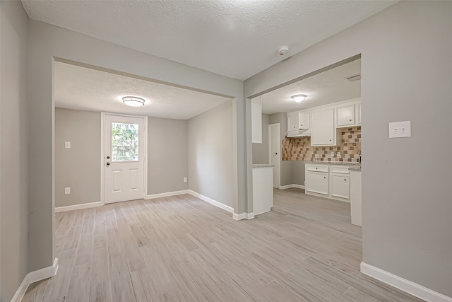 interior space featuring a textured ceiling and light hardwood / wood-style floors