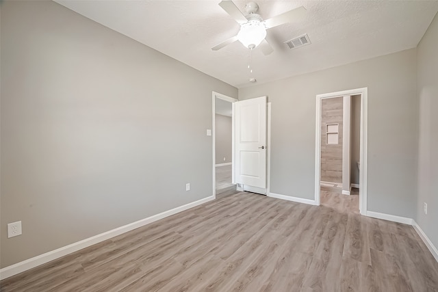 unfurnished bedroom featuring ceiling fan, a textured ceiling, and light wood-type flooring