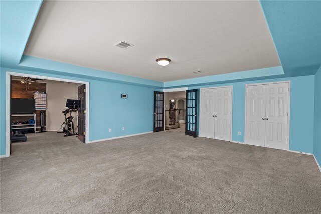 unfurnished bedroom with carpet and a tray ceiling