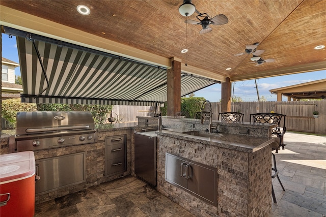 view of patio featuring exterior kitchen, ceiling fan, a grill, and sink