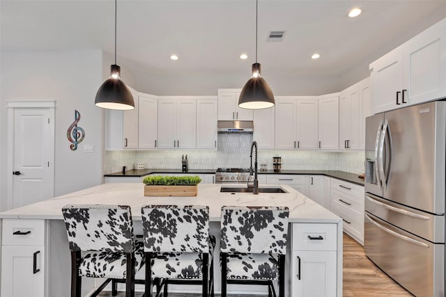 508 E 31st St, Houston, TX 77018 - kitchen with appliances with stainless steel finishes, a sink, decorative backsplash, a kitchen island with sink, and recessed lighting