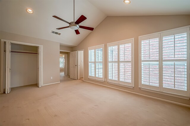 unfurnished bedroom with vaulted ceiling, light carpet, a closet, and ceiling fan