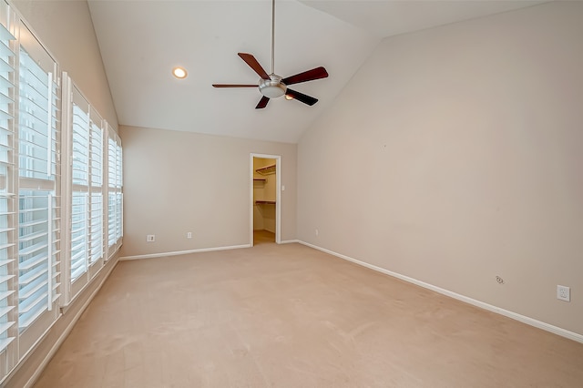 carpeted empty room featuring ceiling fan, a healthy amount of sunlight, and vaulted ceiling