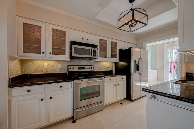 kitchen with decorative light fixtures, white cabinetry, a chandelier, appliances with stainless steel finishes, and tasteful backsplash