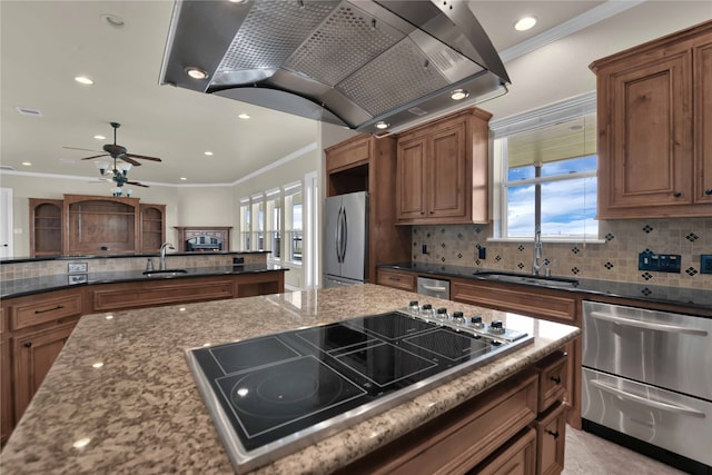 kitchen featuring dark stone counters, stainless steel appliances, sink, and crown molding