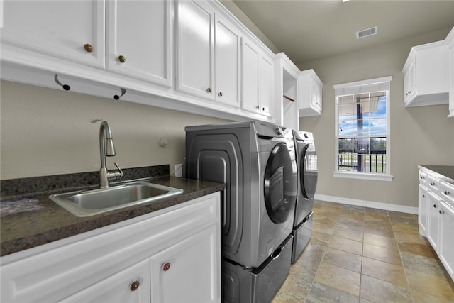 clothes washing area with cabinets, sink, and independent washer and dryer