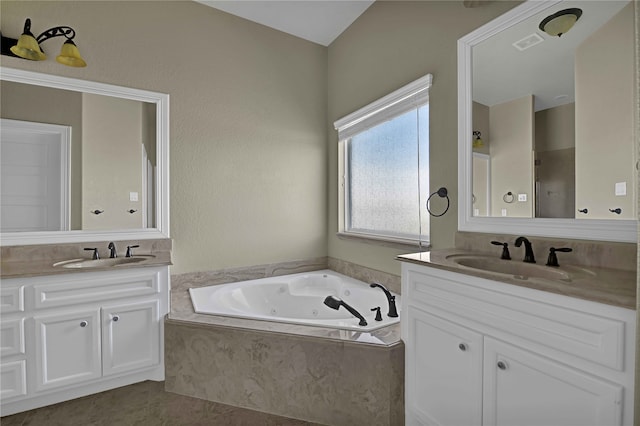 bathroom featuring a relaxing tiled tub, vanity, and tile patterned floors