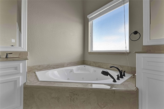 bathroom with a relaxing tiled tub and vanity