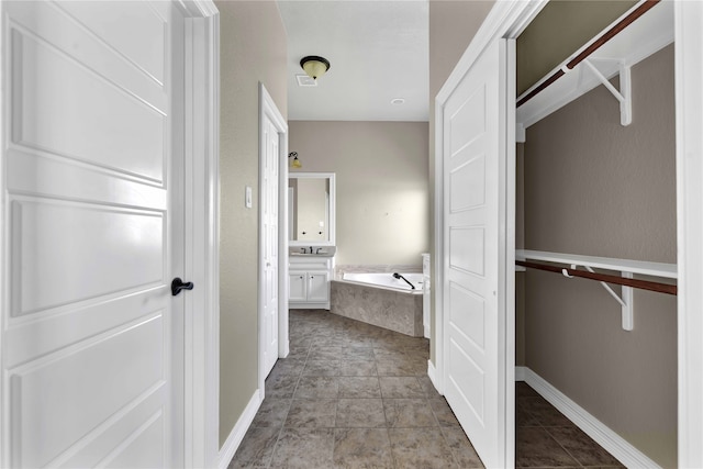 bathroom featuring vanity and a relaxing tiled tub