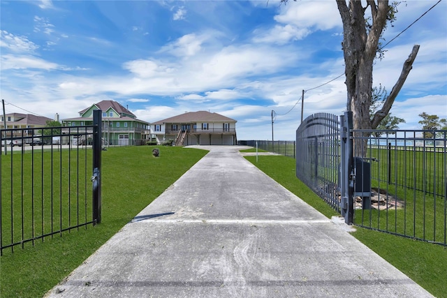 view of gate with a lawn