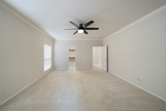 carpeted spare room with crown molding and ceiling fan