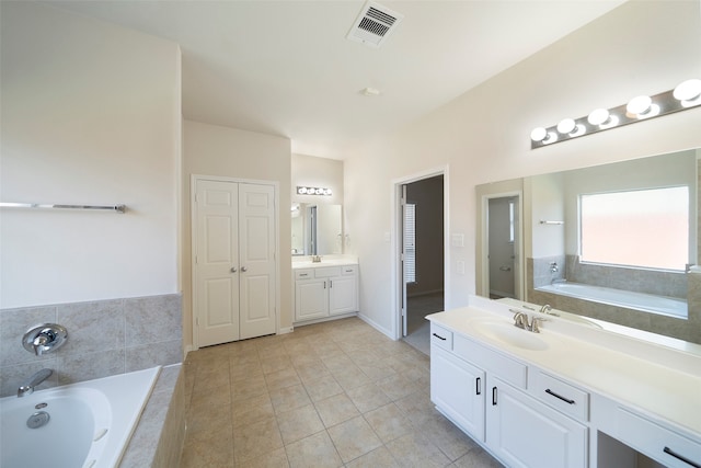 bathroom with vanity, tiled bath, and tile patterned floors