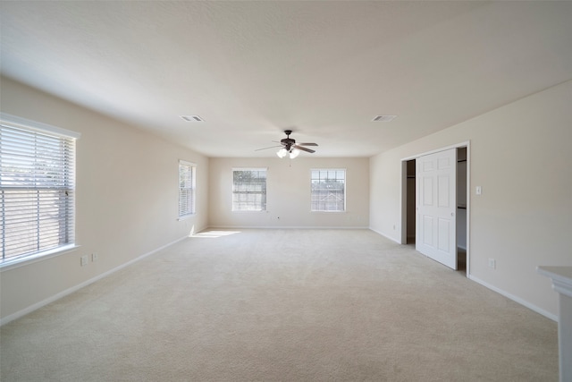 spare room featuring light colored carpet and ceiling fan