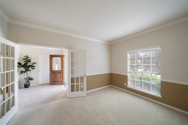 spare room featuring french doors, crown molding, and light colored carpet