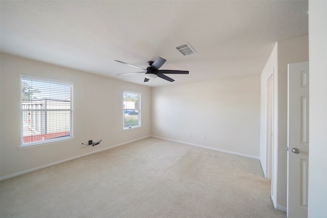 carpeted spare room with ceiling fan