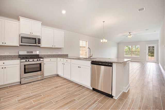 kitchen with white cabinets, light hardwood / wood-style floors, appliances with stainless steel finishes, and sink