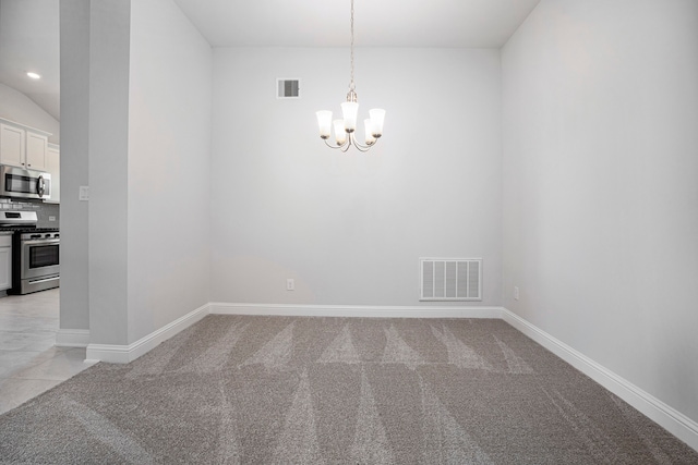 spare room featuring a chandelier and light colored carpet