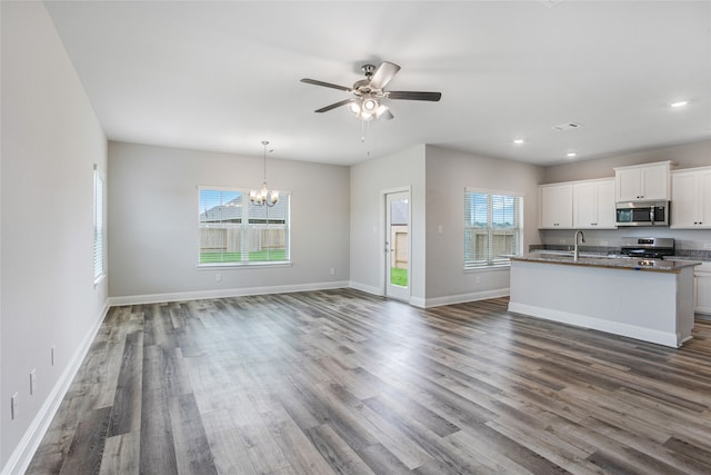 kitchen featuring pendant lighting, dark wood-type flooring, ceiling fan with notable chandelier, white cabinets, and stainless steel appliances