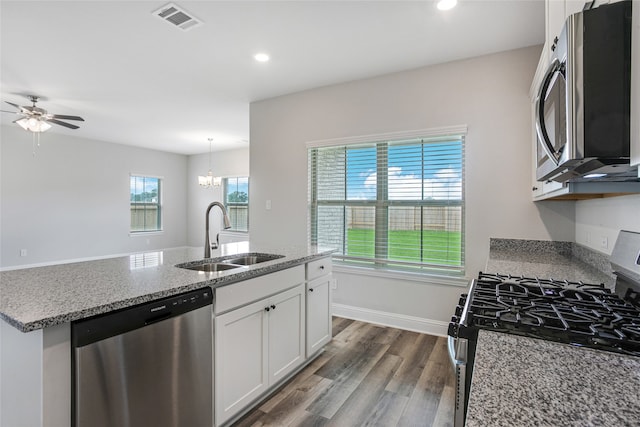 kitchen with dark wood-type flooring, sink, white cabinetry, stainless steel appliances, and light stone countertops