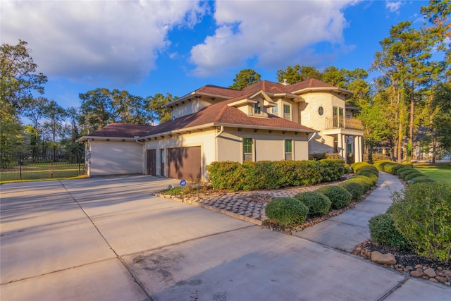 19523 Riverwalk Dr, Porter, TX 77365 - mediterranean / spanish-style house featuring concrete driveway, an attached garage, stucco siding, and fence